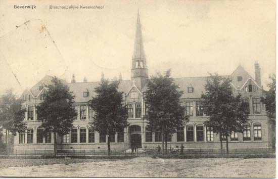 Baanstraat
De Bisschoppelijke Kweekschool gelegen aan de Baanstraat dateert uit 1906, de ansichtkaart is van enkele jaren later. De bisschop van Haarlem nam reeds in 1869 het initiatief tot oprichting van de Vereeniging tot bevordering van het katholiek bijzonder onderwijs. Men bekostigde de opleiding van zgn kwekelingen, jongens die opgeleid werden voor onderwijzer, maar steunde de kwekelingen soms ook financieel. Echter pas in 1897 werd een eigen school opgericht, een kweekschool dus, eerst in Hoorn, maar in 1906 werd de school naar Beverwijk verplaatst. Een nieuw gebouw werd gesticht op grond aangekocht van de familie Waterschoot van der Gracht. De school werd ontworpen door architect J.J.L.Moolenschot. Bij de Kweekschool werd ook de R.K.Leerschool gebouwd, daar konden de kwekelingen praktijk opdoen. Aan de Romerkerkweg en de Kees Delfsweg werden enkele burgerwoonhuizen gebouwd, daar kwamen uiteraard R.K. ingezetenen te wonen die zorgden voor het huisvesten van de kwekelingen, kosthuizen dus. In 1922 werd bij de kweekschool het internaat gebouwd, dat was nodig omdat de kwekelingen ontevreden waren over huisvesting en eten en drinken terwijl de kostbazen vonden dat zij te weinig vergoeding kregen. Het voert te ver de gehele geschiedenis van de Bisschoppelijk Kweekschool hier weer te geven. De school veranderde van naam en werd in later jaren Katholieke Pedagogische Academie Beverwijk. Problemen op velerlei terrein ontstonden er in 1969, er volgde bezetting van de school door de leerlingen, daarna een ontruiming en eigenlijk is het nooit meer goed gekomen. Het leerlingenaantal daalde drastisch, er kwam een samenwerking tot stand met de Opleiding voor het kleuteronderwijs in Bergen en een fusie volgde per 1 januari 1982. De school vertrok naar Bergen, naar de Katholieke PABO de Viaan. De school werd verbouwd, er kwamen 55 wooneenheden in en het appartementencomplex werd in 1989 weer in gebruik genomen. 
Keywords: baanstraat bwijk